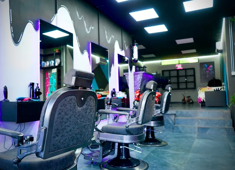 The row of barber chairs and lit mirrors
