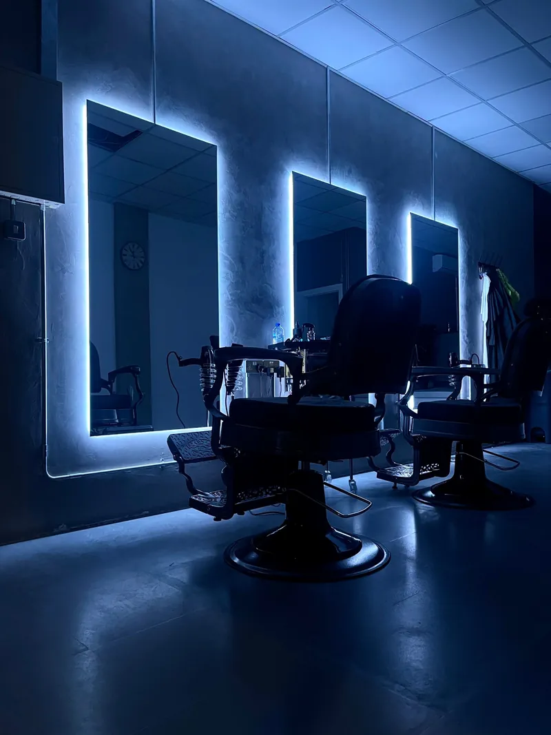 Barber chairs in front of the backlit mirrors at The Barber Lounge